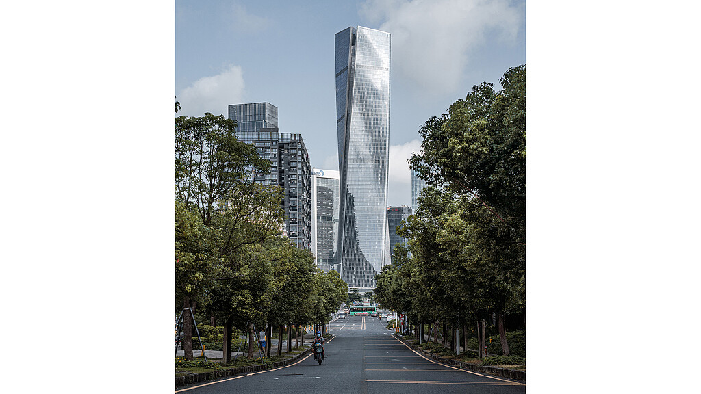 A street with trees and tall buildings.