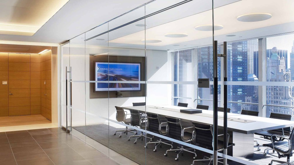 A room with a large glass wall and a tv on the wall.