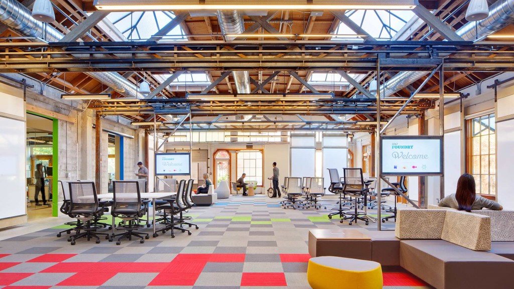 A room with a few people and a few tables and chairs.