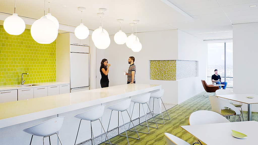A couple of women in a room with white tables and chairs.