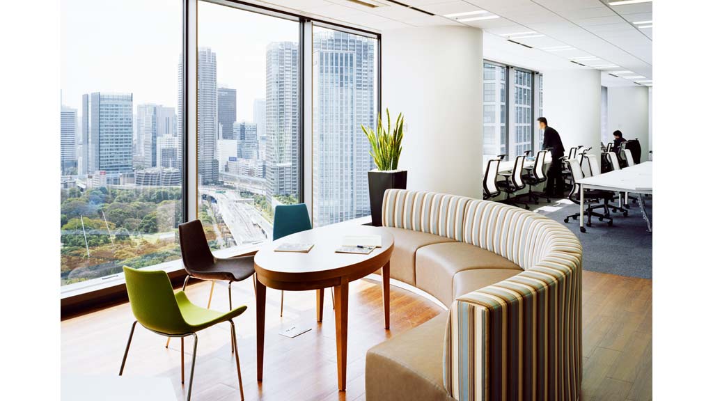 A room with a table chairs and a window with a view of a city.