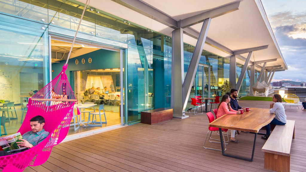 A group of people sitting at a table outside a building.