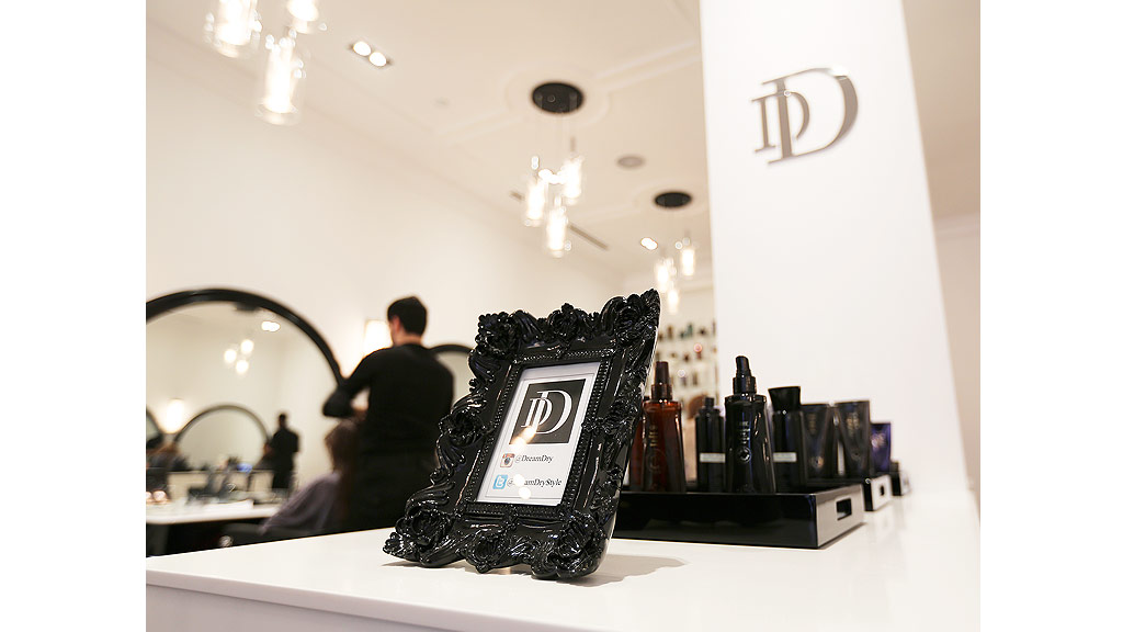 A person sitting at a table with a phone and other objects.