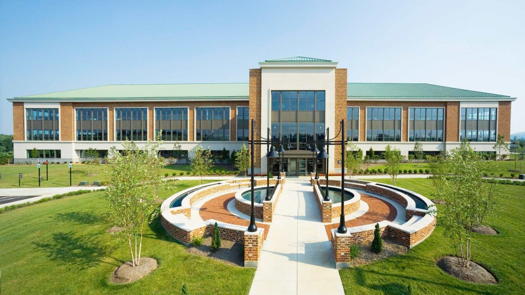 A building with a courtyard and a fountain in front of it.