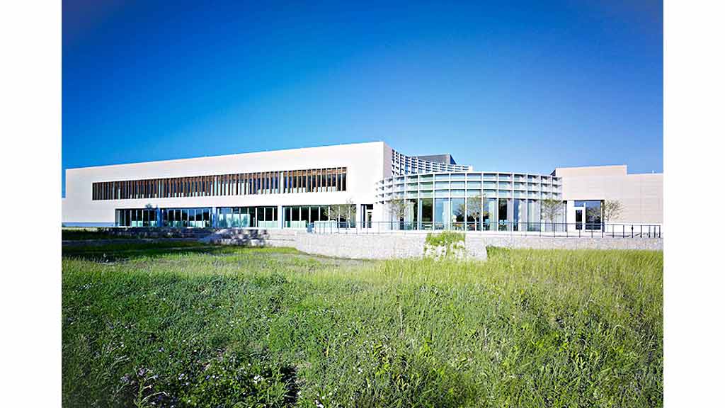 A building with a grass field in front of it.
