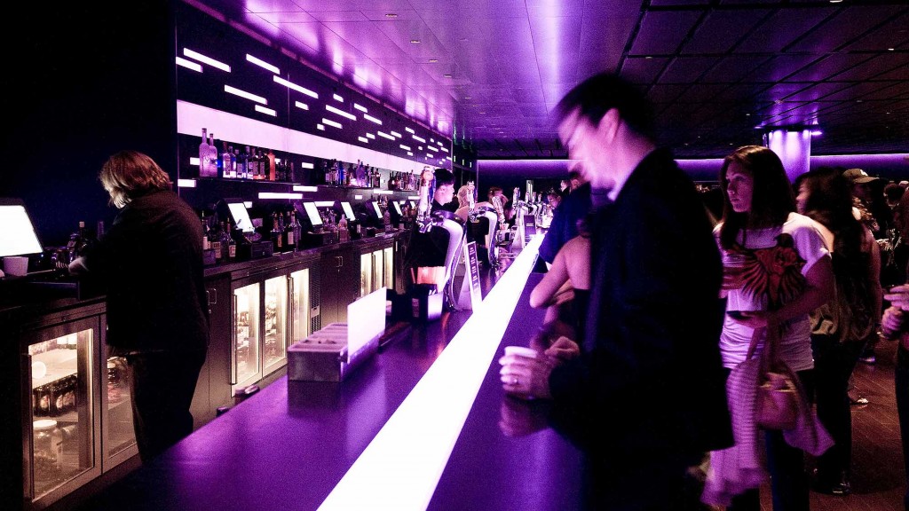 A group of people standing in a room with a large display of lights.