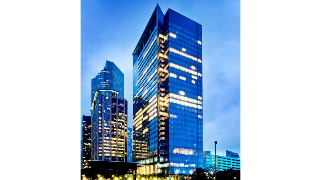 A couple of tall buildings with lights on at night.