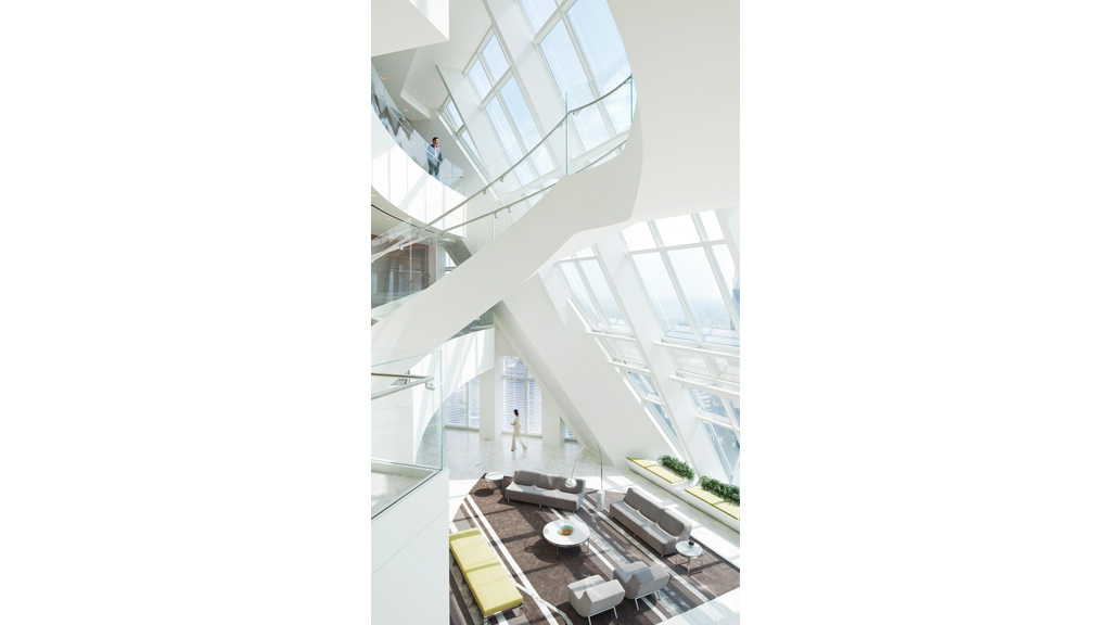 A room with a glass ceiling and a couple of people walking around.