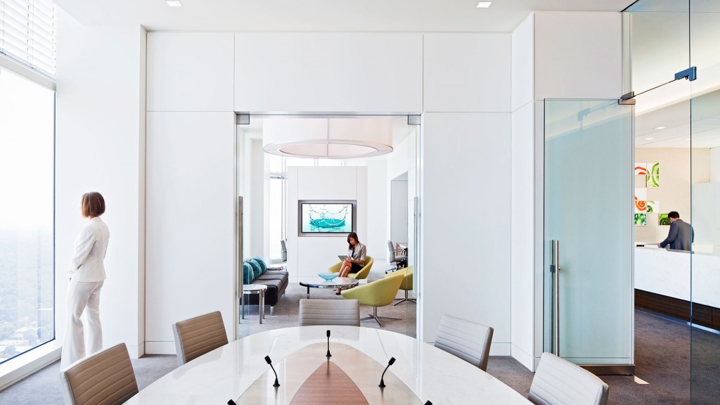 A room with a glass table and a couple of people in it.