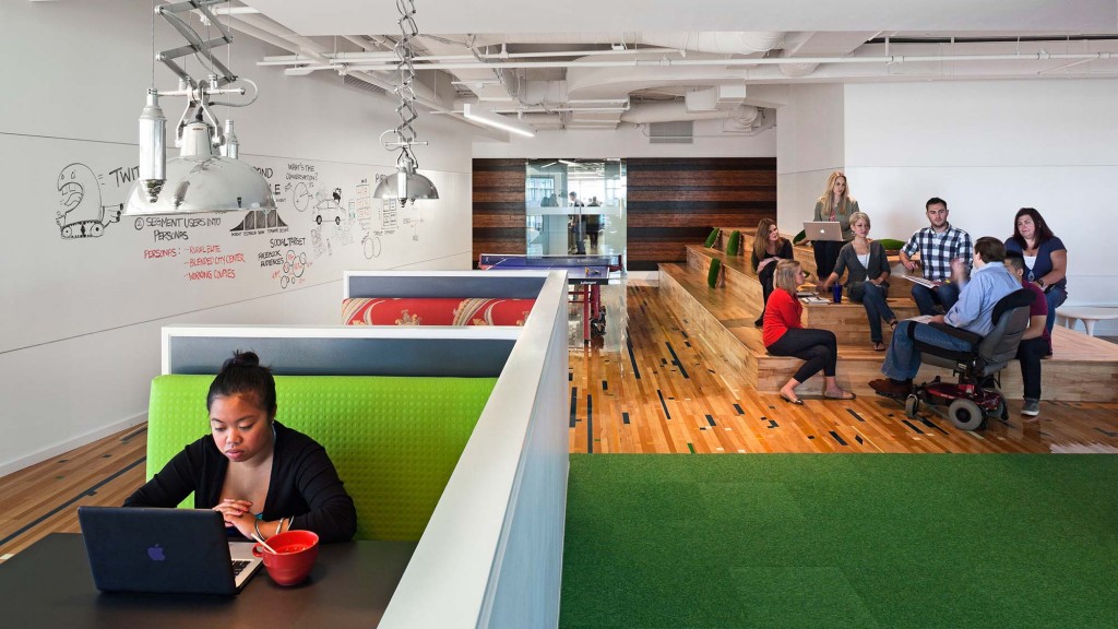 A group of people sitting in a room with a laptop and a table.