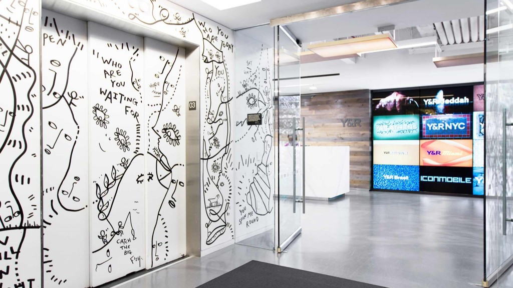 A room with a glass wall and a large screen.