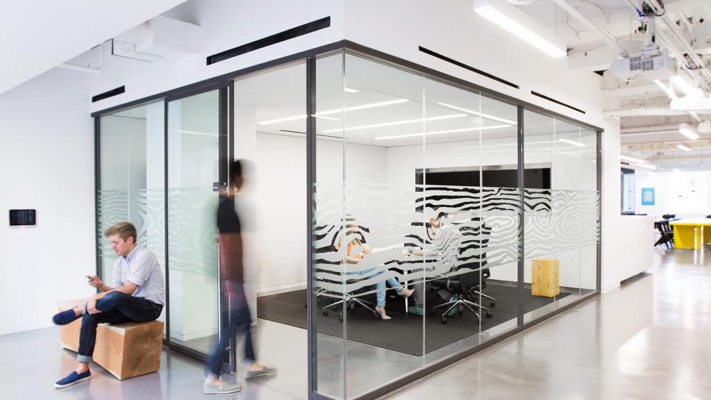A person sitting on a chair in a room with glass walls.
