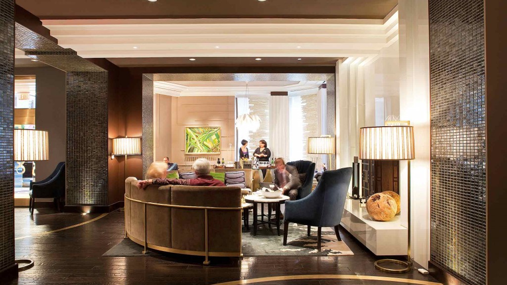 A group of people sitting in a room with a large table and chairs.