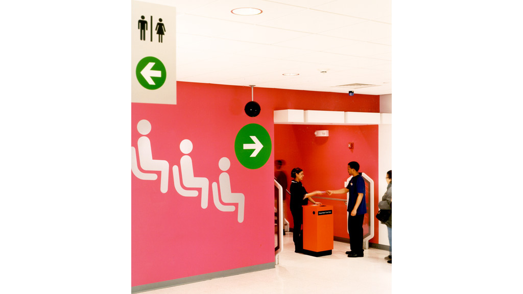 A group of people standing in front of a red wall.