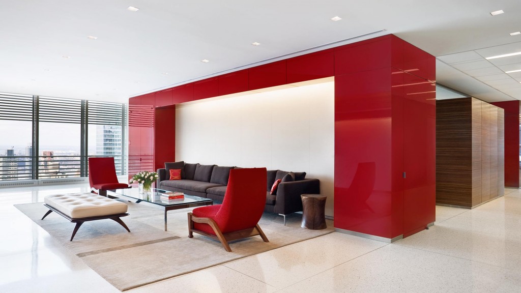 A room with a couch and chairs.