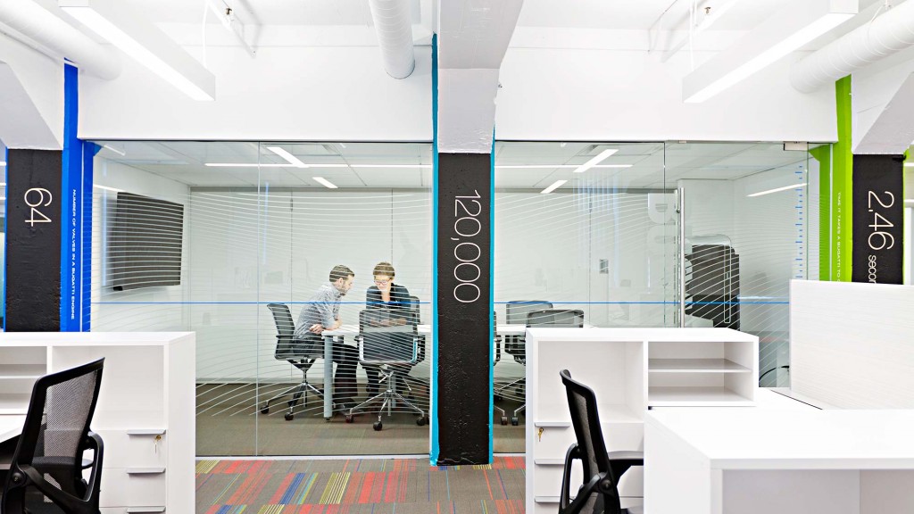 A couple of people sitting at a table in a room with white walls.