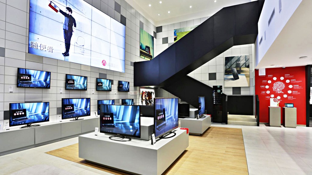 A room with a display of televisions and a large screen.