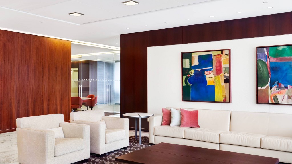 A room with white couches and a table.