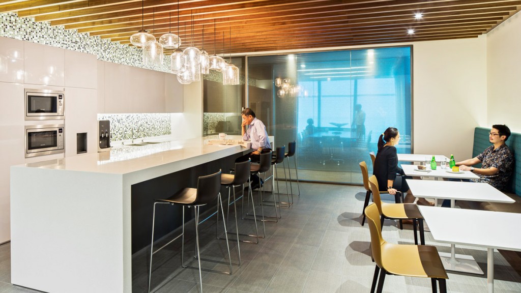 A group of people sitting at a table in a room with white walls.