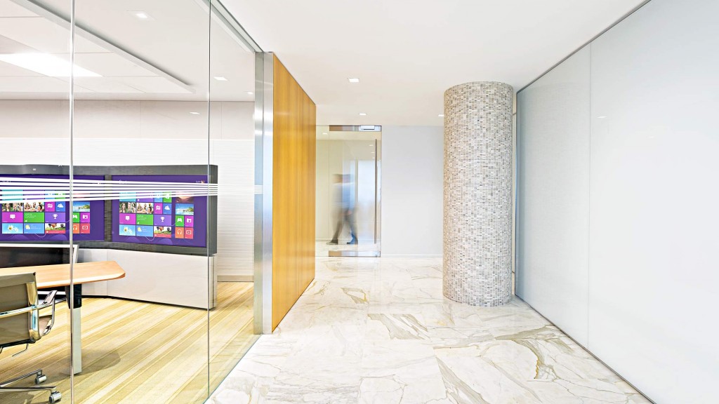A large room with a glass wall and a large display of televisions.