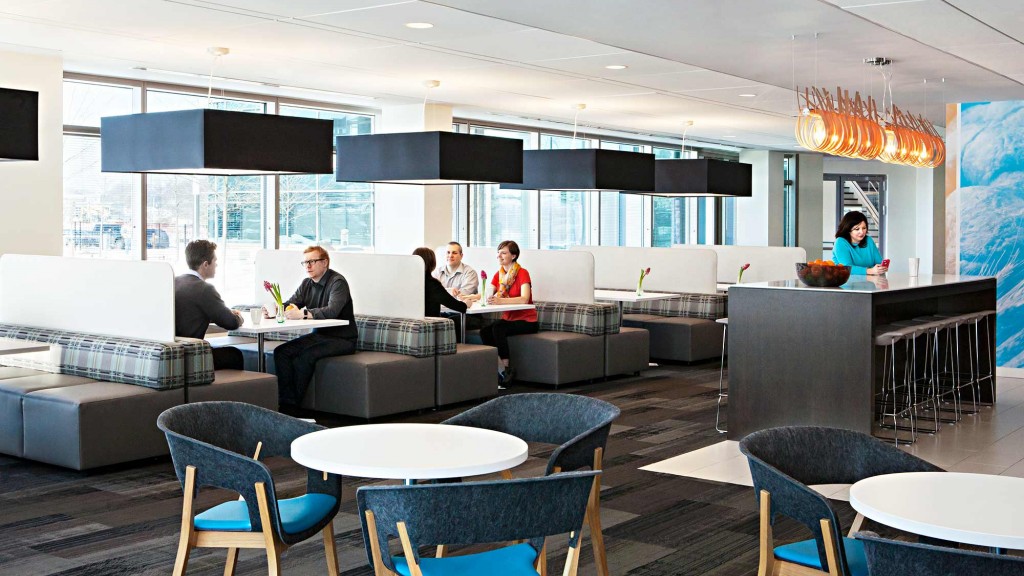 A group of people sitting at a table in a room with a large window.