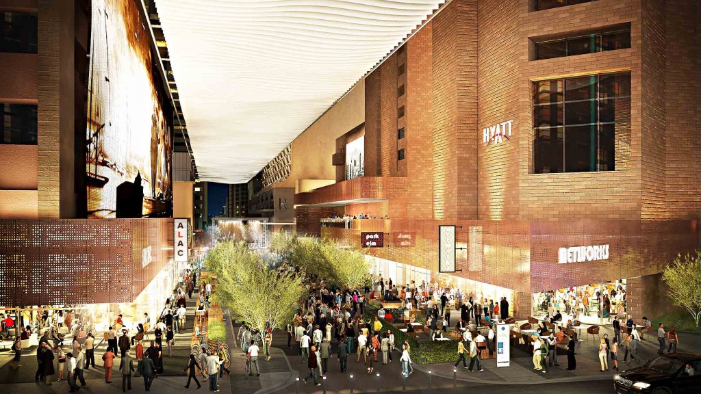 A group of people walking on a street between buildings.