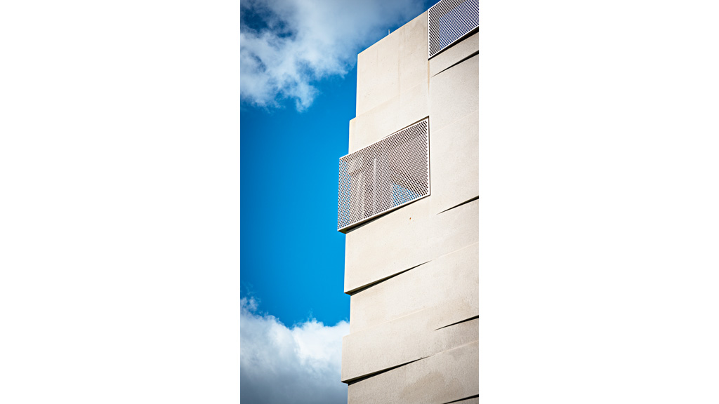 A tall white building with a square window.