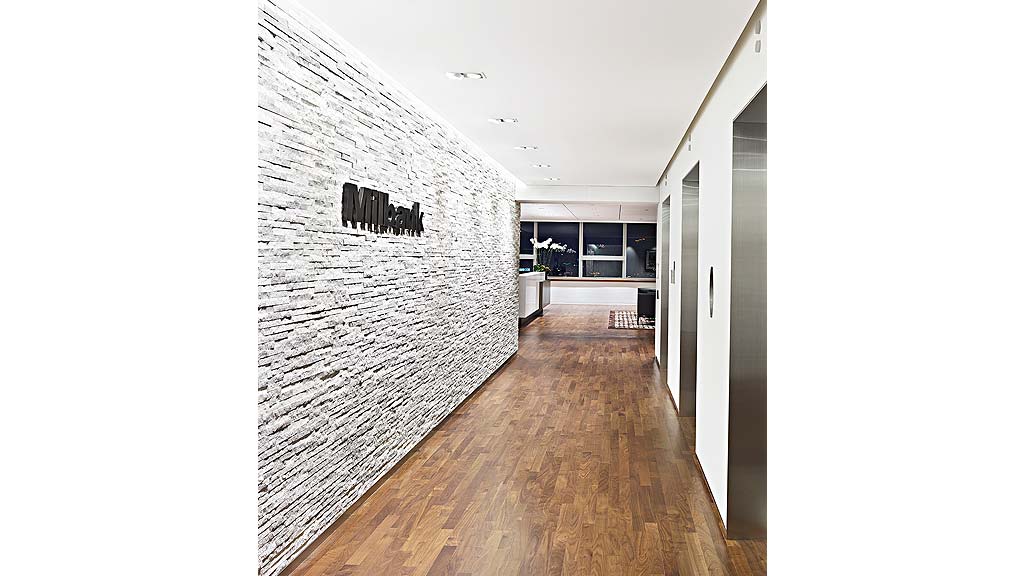 A room with a wood floor and a wood floor with a white wall.