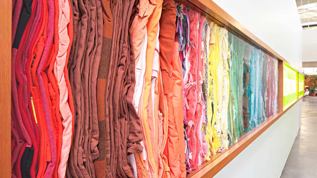 A row of red and yellow clothes on a wall.