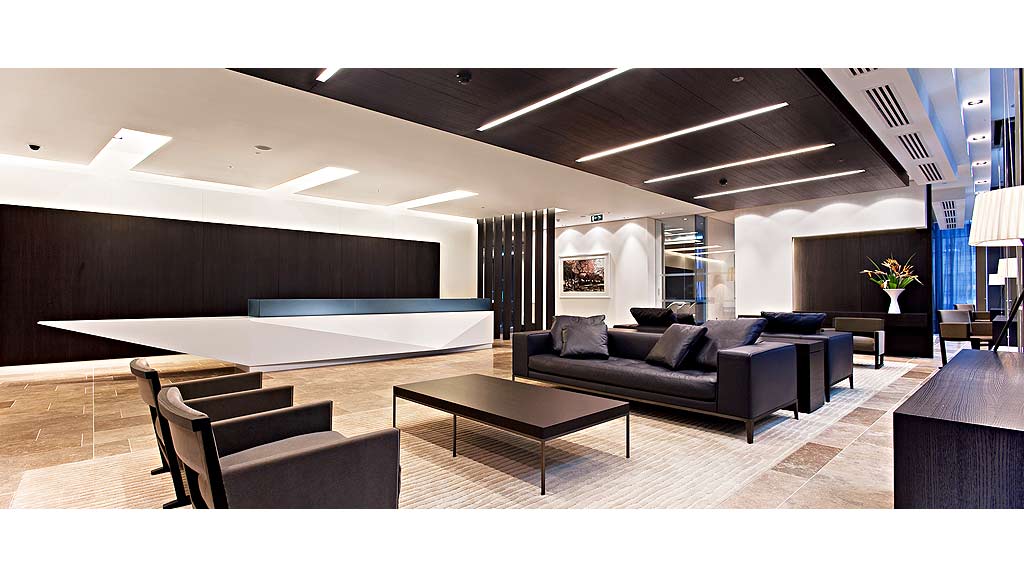 A room with a couch and chairs.