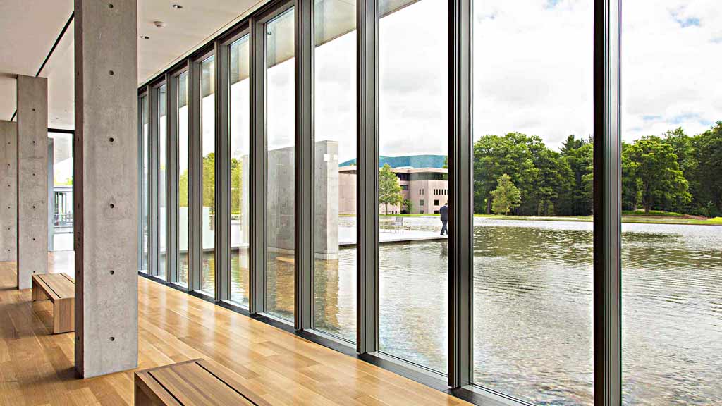 A building with windows and a body of water in the background.