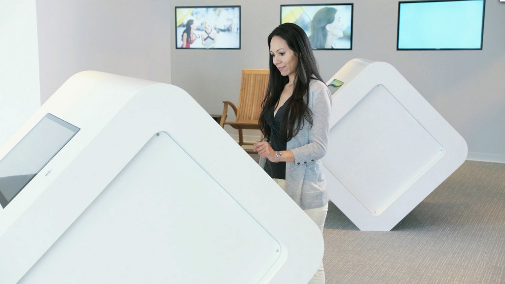 A woman standing next to a white table with a white box on it.