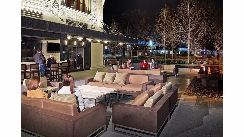 A group of people sitting on couches outside a building at night.