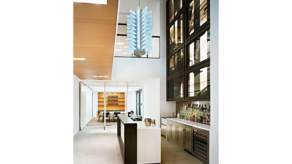 A large room with a large blue chandelier and a bar.