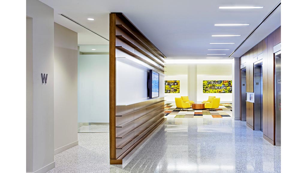 A hallway with a wood staircase.