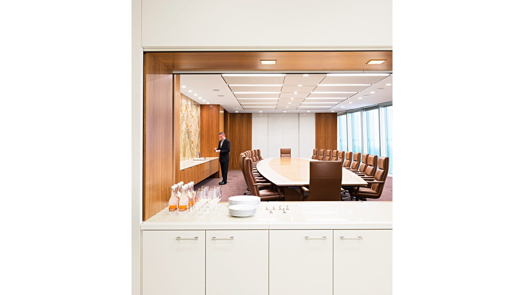 A person standing in a room with a table and chairs.
