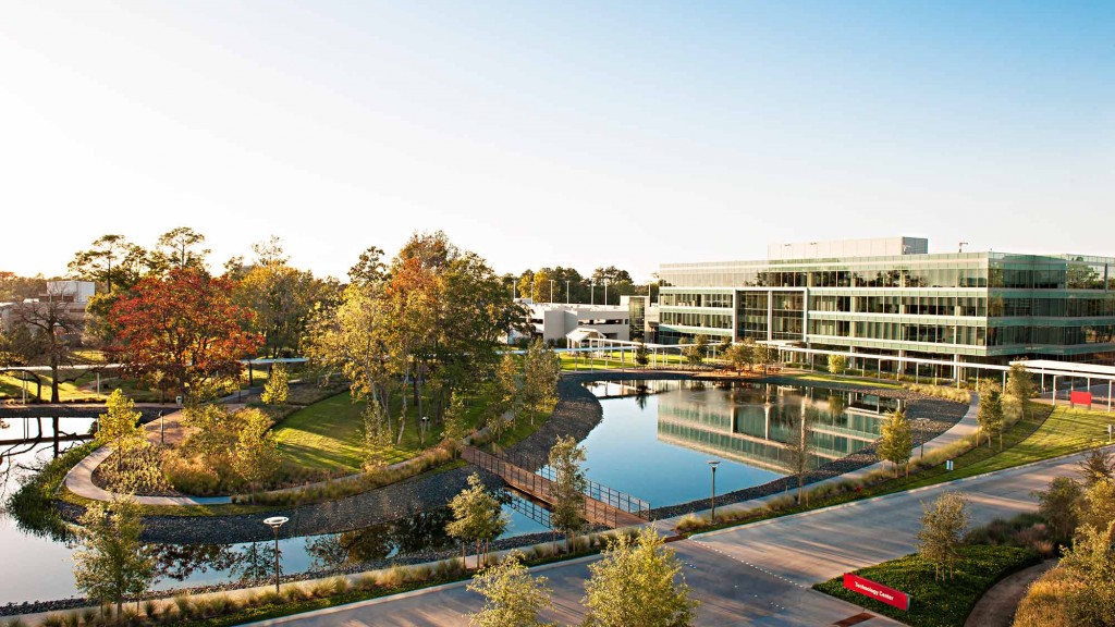 A large building with a pool in front of it.