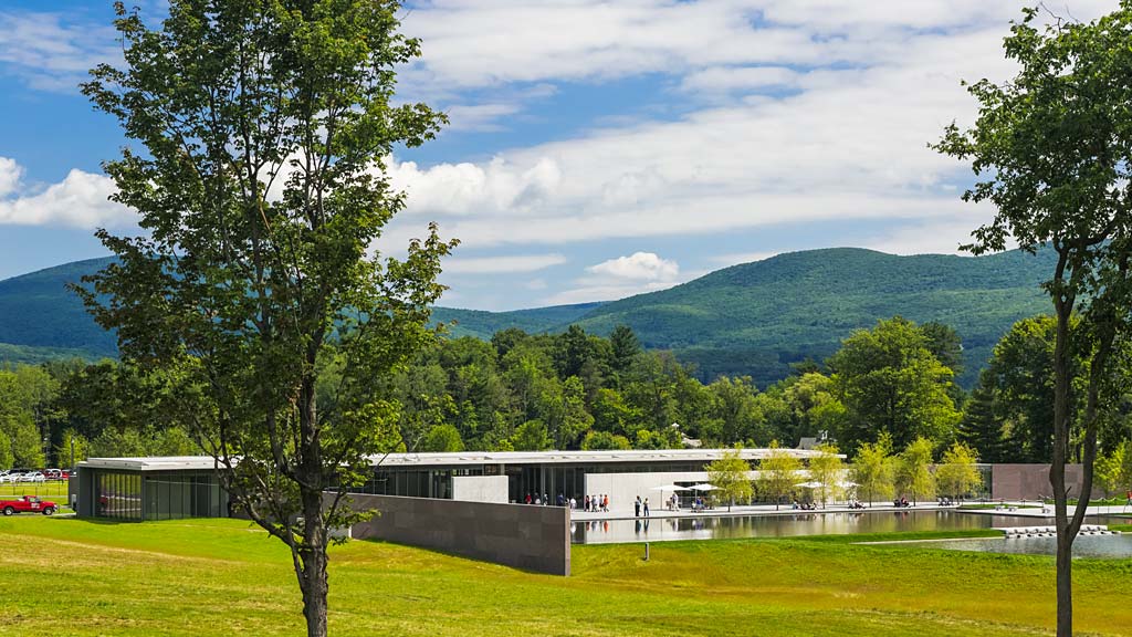 A building with trees and grass in front of it.