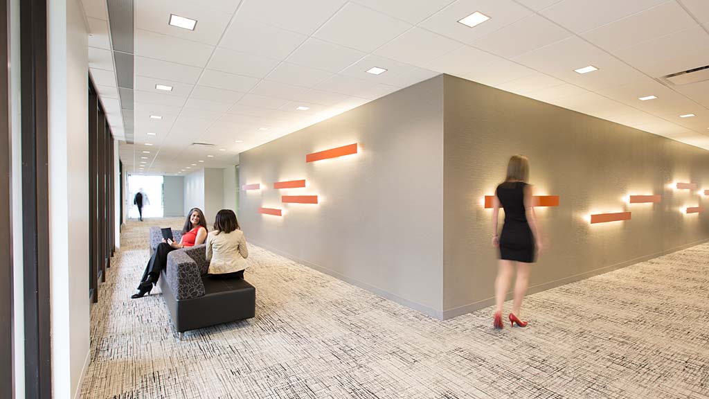A person standing in a room with people sitting on chairs.