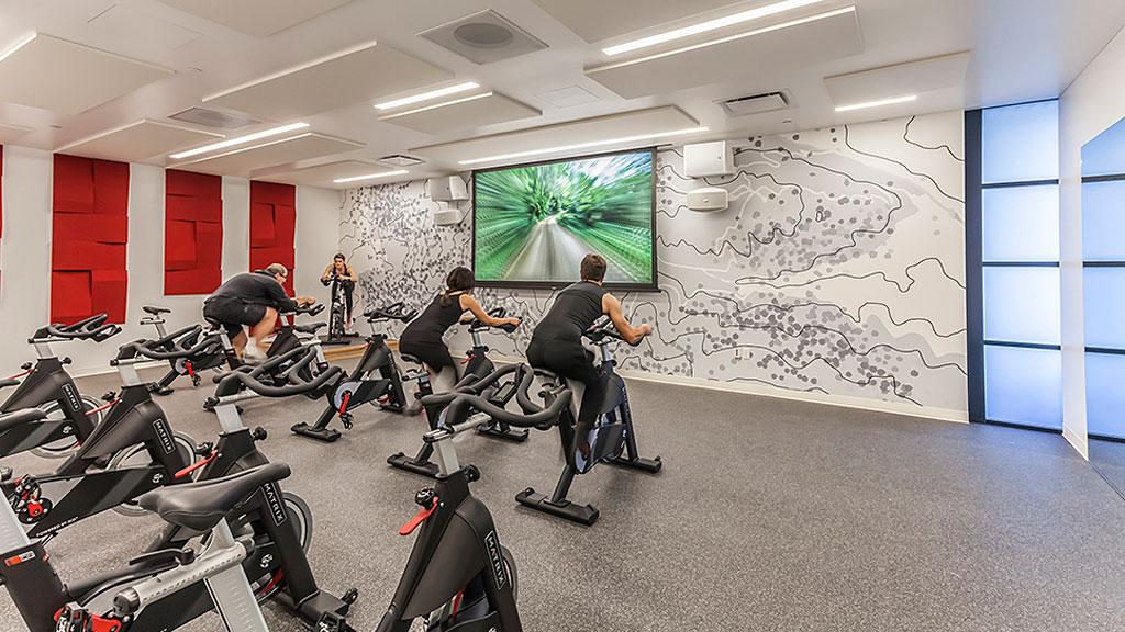 A group of people sitting in a room with bikes and a map.