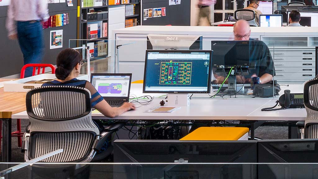 A man and a woman working on a computer.