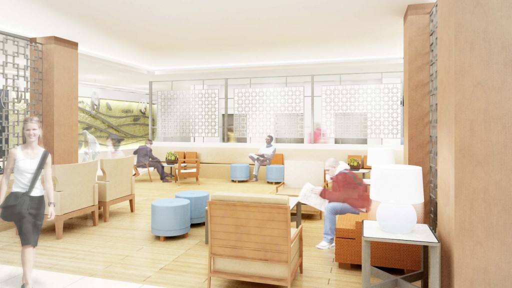 A woman standing in a room with a man sitting in a chair.