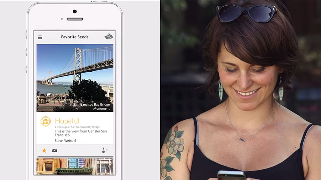 A woman smiling and looking at a phone.