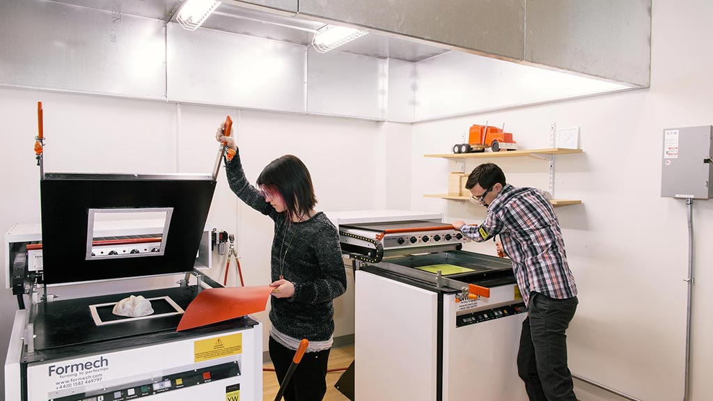 A man and woman in a room with computers and equipment.