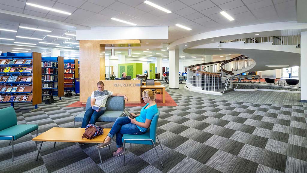 A man and a woman sitting in a library.