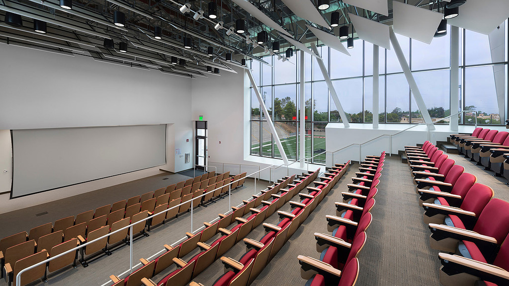 A room with red chairs and a whiteboard.