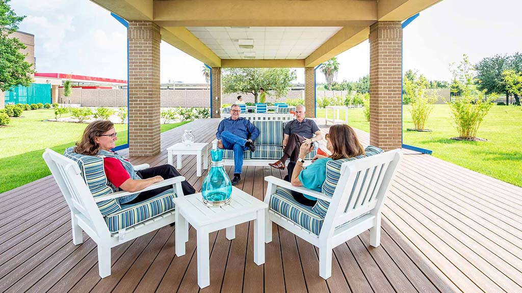 A group of people sitting on a deck.
