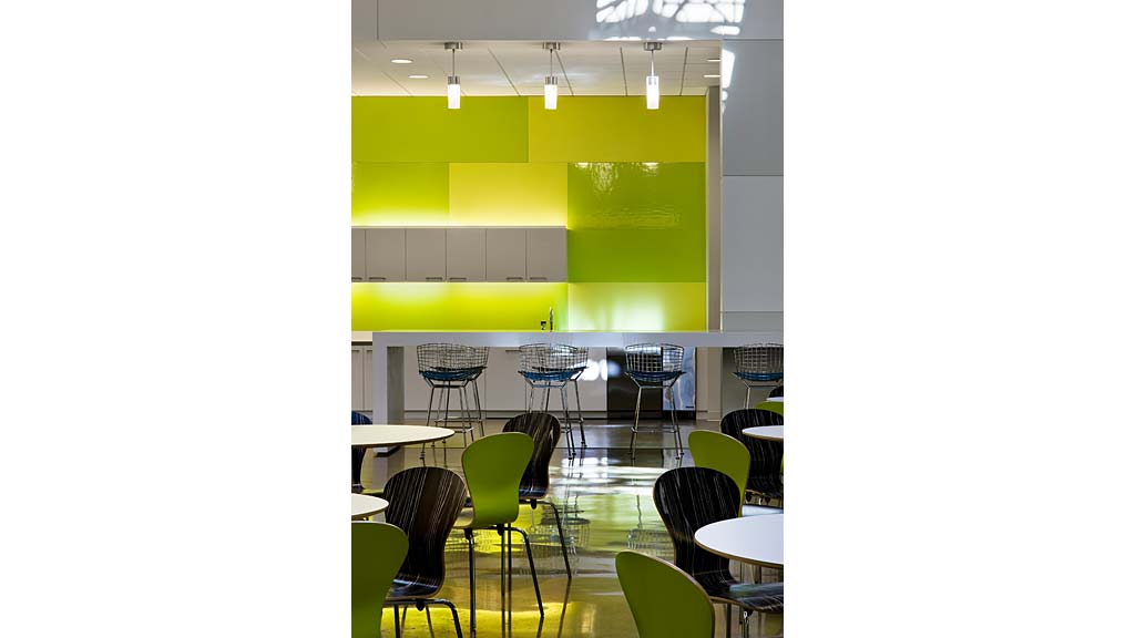 A classroom with green chairs and tables.