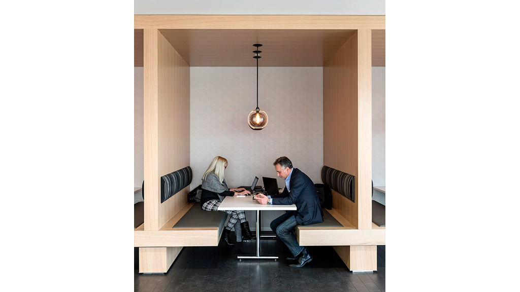 A man and a woman sitting at a table with laptops.
