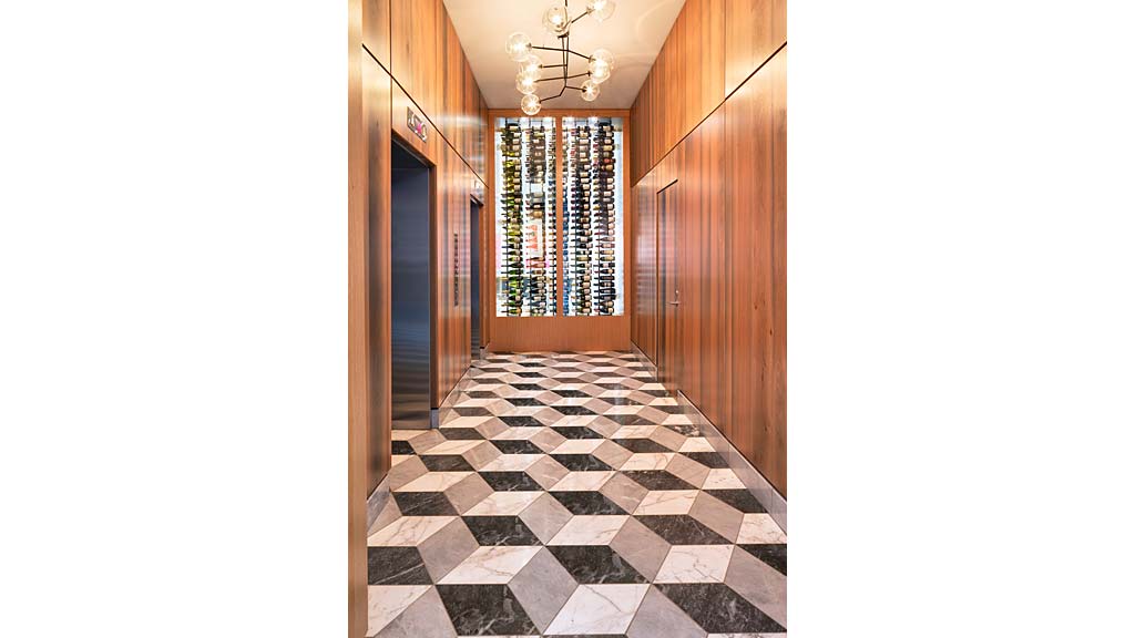 A hallway with a tile floor and a chandelier.